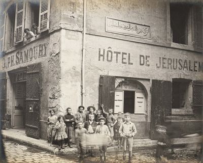 an old photo of a group of people standing outside of a hotel