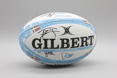 un ballon de rugby sur lequel est inscrit le nom « Gilbert »