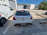 a white car parked in a parking lot next to a white van