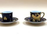 deux tasses et soucoupes sont posées sur une surface blanche