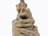 statue d'une femme assise sur un rocher, avec un oiseau perché sur son épaule