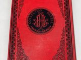 a red book with a black border and a monogram on it