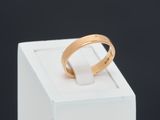 a close up of a gold ring sitting on top of a white box