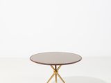 une table basse ronde avec des pieds dorés et un plateau blanc