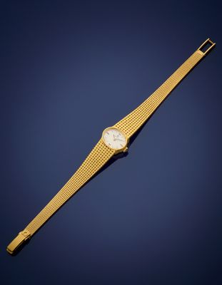 a gold wrist watch with a white dial on a blue background