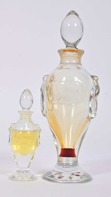 une petite bouteille en verre et une autre petite bouteille en verre, l'une à côté de l'autre