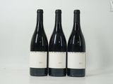 trois bouteilles de vin sont posées sur une table