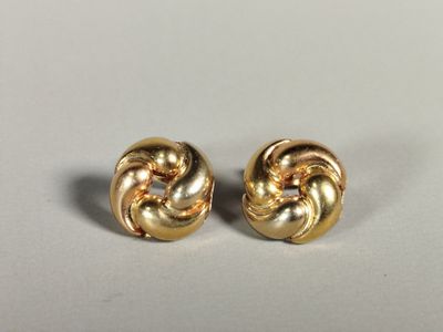 a pair of gold toned earrings on a white surface