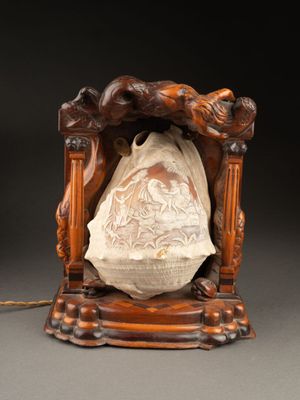 LAMPE architecturée, centrée d'un coquillage sculpté en camé…