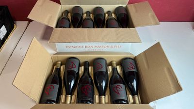 six bouteilles de vin dans un carton sur une table