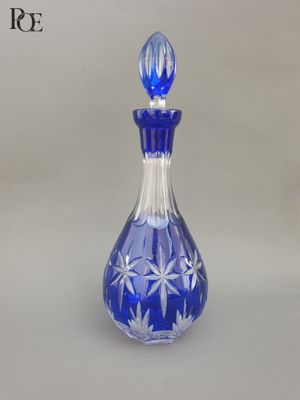 une bouteille en verre bleue décorée de fleurs blanches