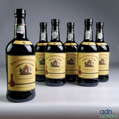 six bouteilles de vin sont alignées sur une table