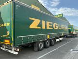 un gros camion garé devant un immeuble