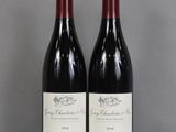 two bottles of wine sitting on a glass table