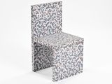 une chaise en papier avec un motif sur le dossier
