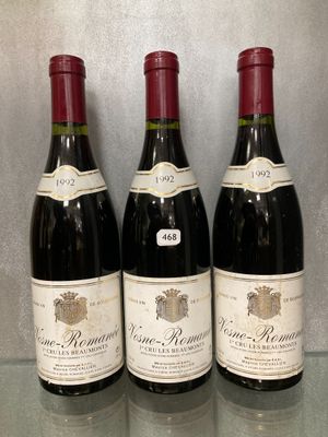 trois bouteilles de vin sont alignées sur une table en verre