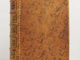 un vieux livre à la couverture brune posé sur une table