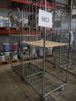 une grande cage métallique portant un numéro, dans un entrepôt
