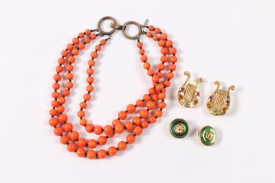 un collier de perles orange accompagné d'une paire de boucles d'oreilles, posé sur un fond blanc