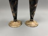 pair of black and gold vases sitting on top of a white table