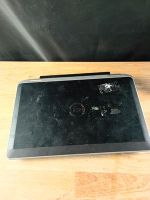 un ordinateur portable cassé posé sur une table en bois