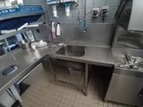 a large stainless steel kitchen with a sink and a dishwasher