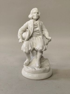 une figurine blanche représentant un homme avec un chapeau et un manteau