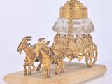 a gold carriage with a horse drawn carriage on a marble base