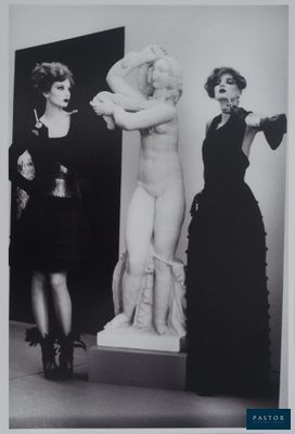 black and white photograph of two women standing in front of a statue