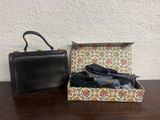 a black purse and tie in a box on a table