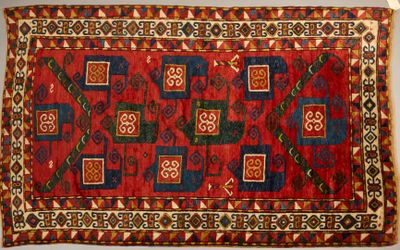 a close up of a red and blue rug on a white surface