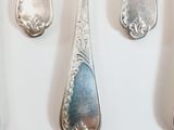 several spoons and forks are lined up on a white surface