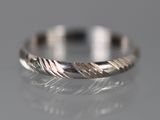 un gros plan d'une bague en argent sur une surface réfléchissante