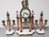 a clock that is sitting on top of a set of candles