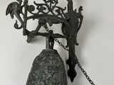 a bell hanging on the wall with a chain around it