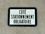 un panneau en noir et blanc sur lequel on peut lire « Cote Station Nement Obligatre »
