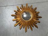 a gold sunburst sitting on the floor in a room