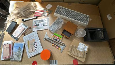 une table sur laquelle se trouvent de nombreux objets, notamment des stylos, des crayons, des ciseaux et un téléphone portable