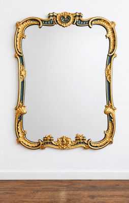 un miroir à cadre doré accroché à un mur blanc dans une pièce