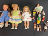 a lot of dolls that are sitting on a black surface