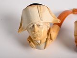 a carved pipe and a carved figurine of a man