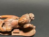 an image of a statue of a man laying down on a leaf