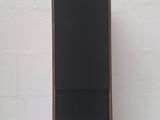a close up of a speaker on a table near a brick wall
