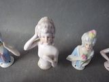 three figurines of children sitting next to each other