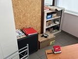 a desk with a chair and a book shelf in the corner