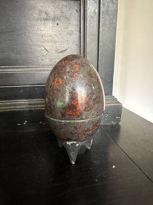 an egg sitting on a stand on a black table