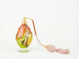 une petite bouteille en verre avec une anse rose sur un fond blanc