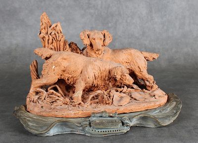 une statue représentant un chien et deux chiens sur un rocher