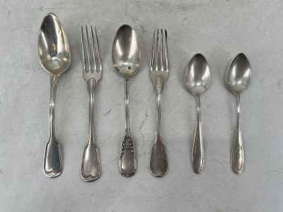 cinq cuillères et une fourchette sur une table