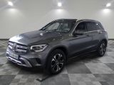 Une Mercedes GLC grise est garée dans une grande pièce